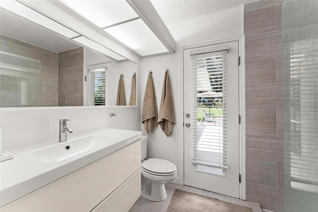 bathroom with a textured ceiling, vanity, and toilet