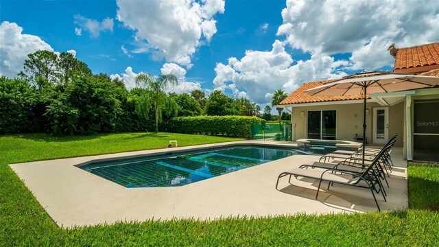 view of pool with a lawn and a patio area