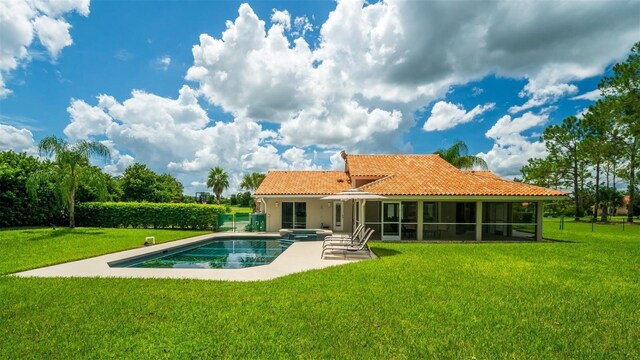 back of house with a sunroom, a fenced in pool, a lawn, and a patio area