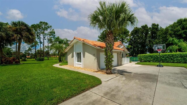 view of side of property with a garage and a lawn