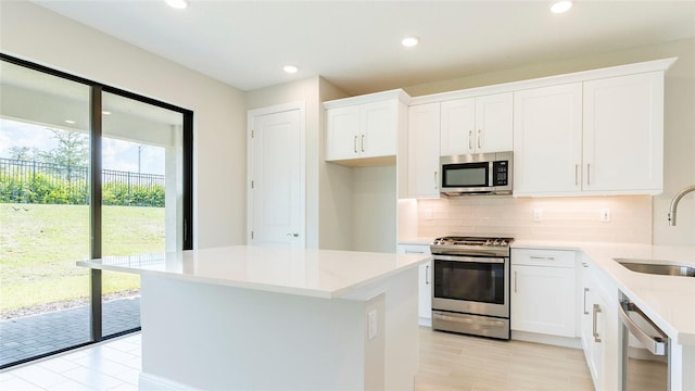 kitchen with white cabinetry, sink, a center island, and appliances with stainless steel finishes