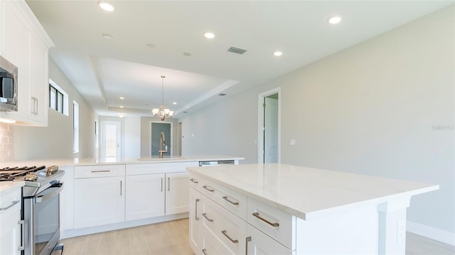 kitchen featuring white cabinetry, sink, a center island, and appliances with stainless steel finishes