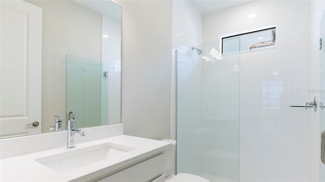 bathroom featuring vanity, toilet, and a shower with door