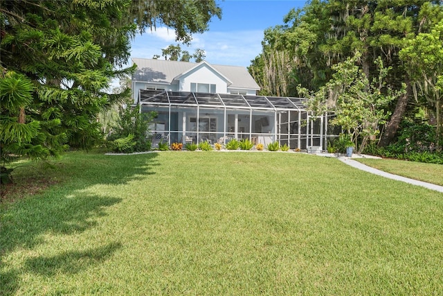 rear view of property with glass enclosure and a lawn