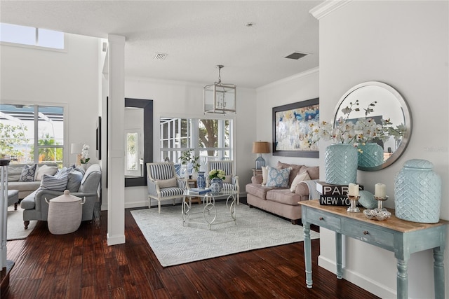 living room with a chandelier, dark wood-type flooring, and ornamental molding