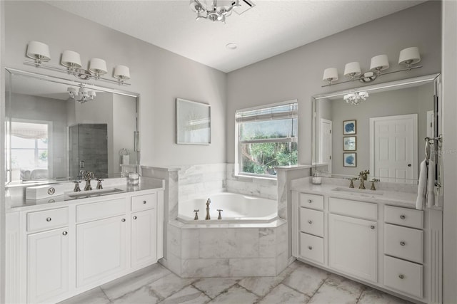 bathroom featuring a textured ceiling, vanity, and shower with separate bathtub