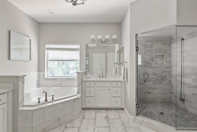 bathroom with a textured ceiling, vanity, and independent shower and bath