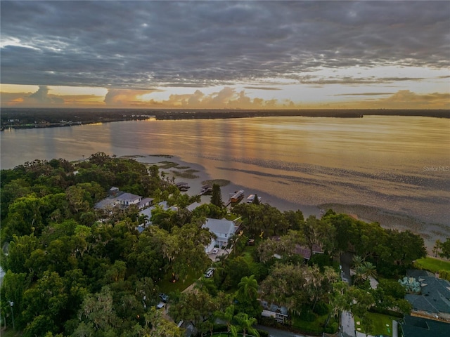 aerial view at dusk featuring a water view