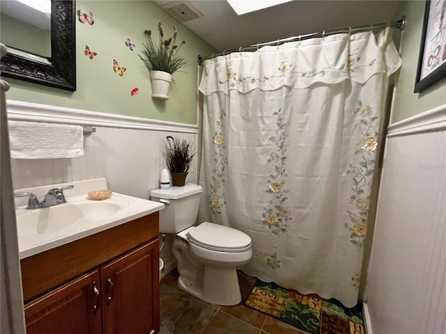 bathroom featuring vanity, toilet, walk in shower, and tile patterned flooring