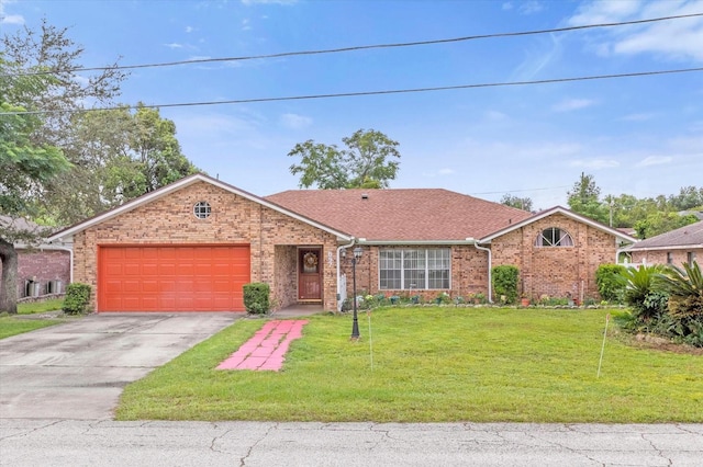 single story home featuring a garage, driveway, a front lawn, and brick siding