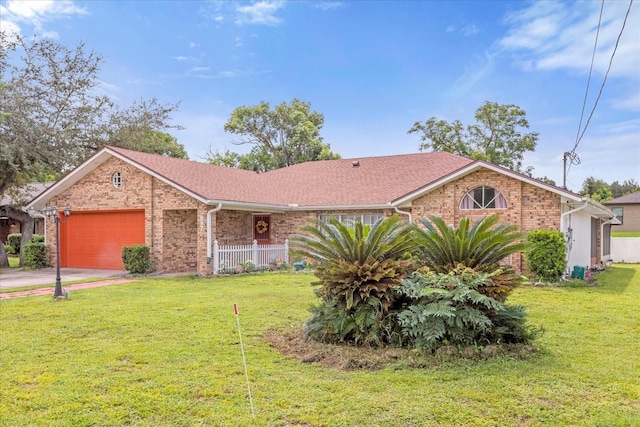 single story home featuring driveway, a front lawn, an attached garage, and brick siding