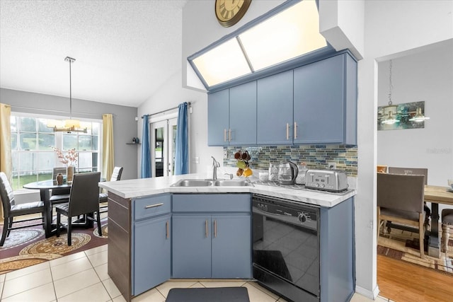 kitchen with black dishwasher, blue cabinetry, light countertops, a sink, and a peninsula