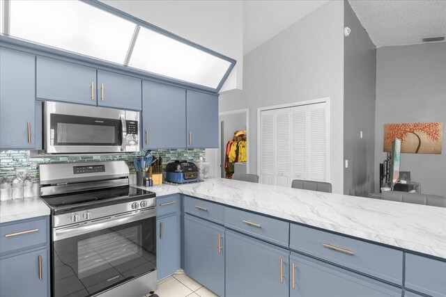 kitchen with visible vents, decorative backsplash, light stone counters, stainless steel appliances, and blue cabinetry