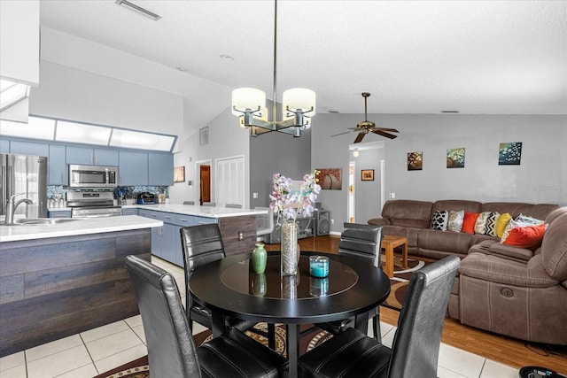 dining space featuring ceiling fan with notable chandelier, visible vents, and light tile patterned flooring