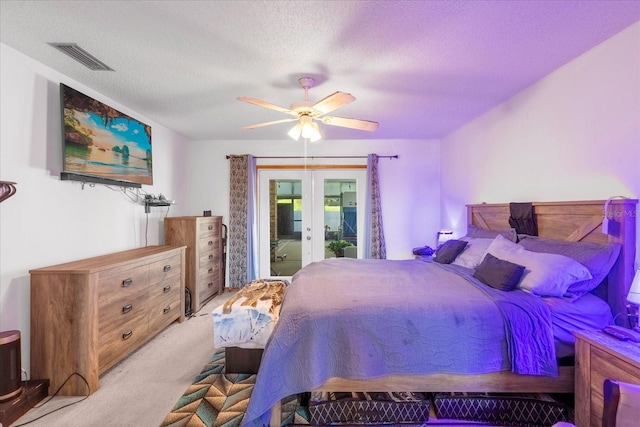 bedroom with a textured ceiling, light carpet, visible vents, access to exterior, and french doors