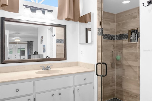 full bathroom featuring a stall shower, ceiling fan, and vanity