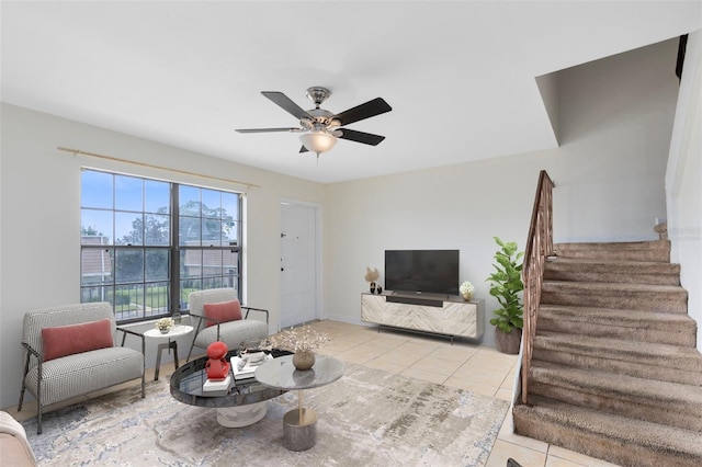 living room featuring light tile patterned floors, stairway, and a ceiling fan