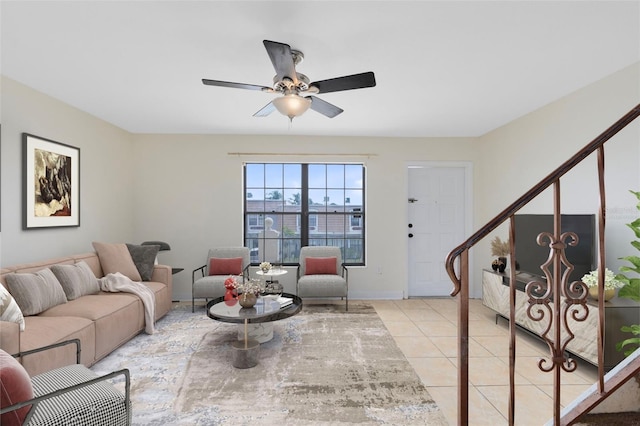 living area featuring ceiling fan, baseboards, and light tile patterned floors