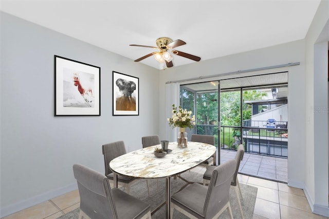 dining area featuring ceiling fan, baseboards, and light tile patterned floors