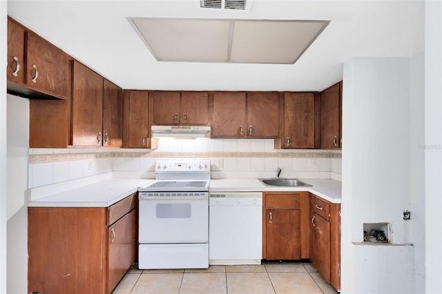 kitchen with white appliances, light countertops, a sink, and under cabinet range hood