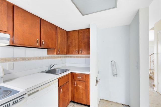 kitchen featuring light tile patterned floors, light countertops, backsplash, a sink, and white appliances