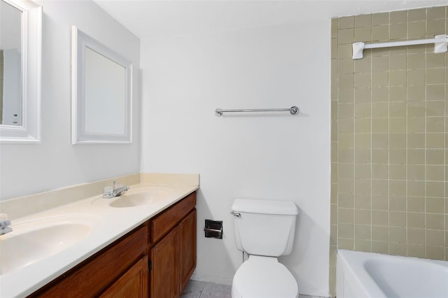 full bath with double vanity, a sink, toilet, and tile patterned floors