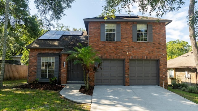 view of front facade with a garage, a front lawn, and solar panels