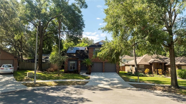 view of front of home with solar panels, a front yard, fence, a garage, and driveway