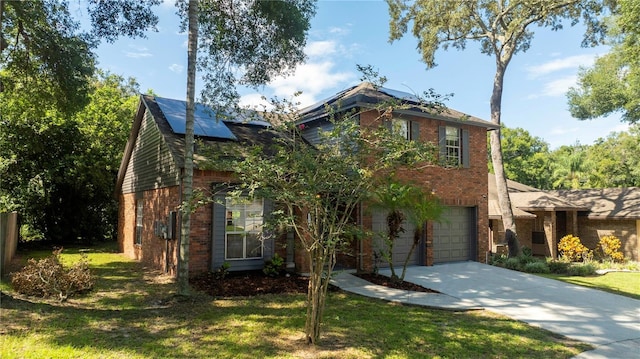 view of front of house featuring driveway, roof mounted solar panels, a front lawn, and brick siding