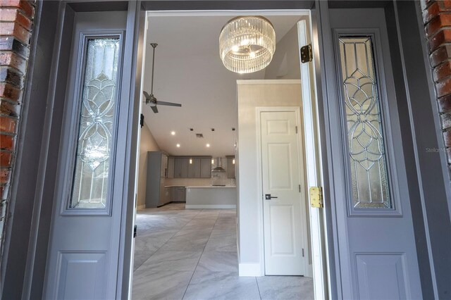 entryway with a notable chandelier and brick wall