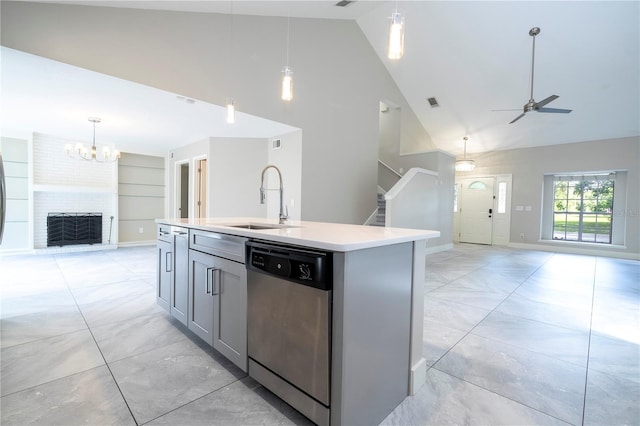 kitchen featuring a fireplace, ceiling fan with notable chandelier, sink, a kitchen island with sink, and stainless steel dishwasher