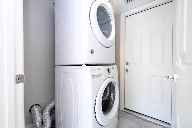 clothes washing area with stacked washer / dryer and light tile patterned flooring