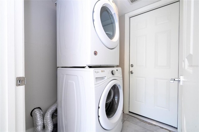 laundry area with light tile patterned floors, laundry area, and stacked washer / dryer