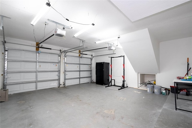 garage with a garage door opener and freestanding refrigerator