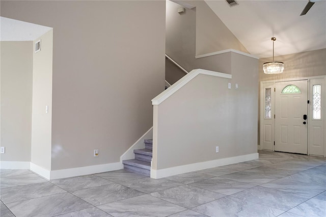 entryway with ceiling fan with notable chandelier and high vaulted ceiling