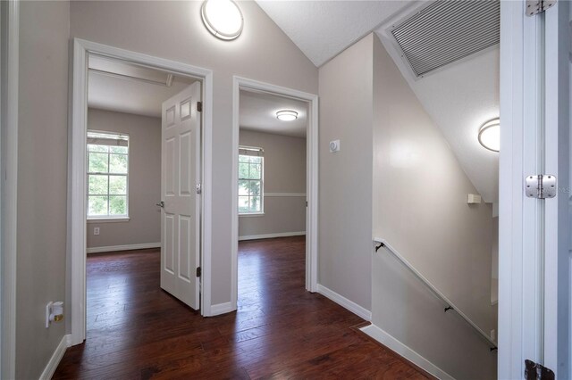 hallway featuring vaulted ceiling and dark hardwood / wood-style floors