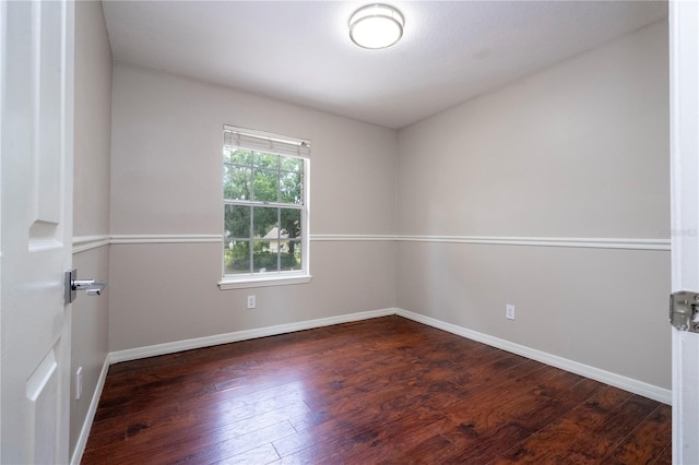 unfurnished room with dark hardwood / wood-style flooring