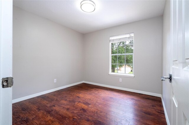 unfurnished room with dark wood-type flooring