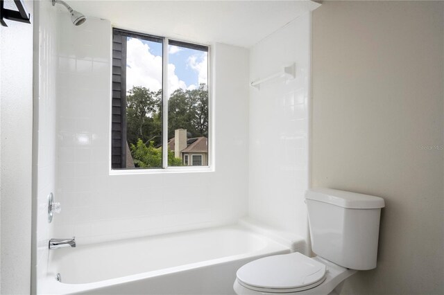 bathroom featuring washtub / shower combination and toilet