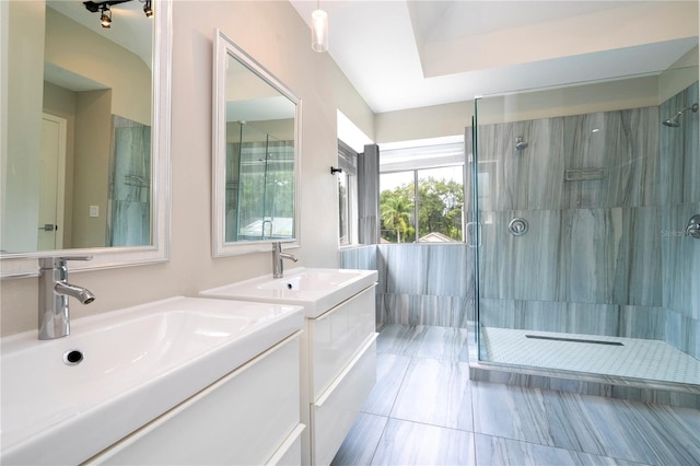 full bathroom featuring a stall shower, two vanities, and a sink