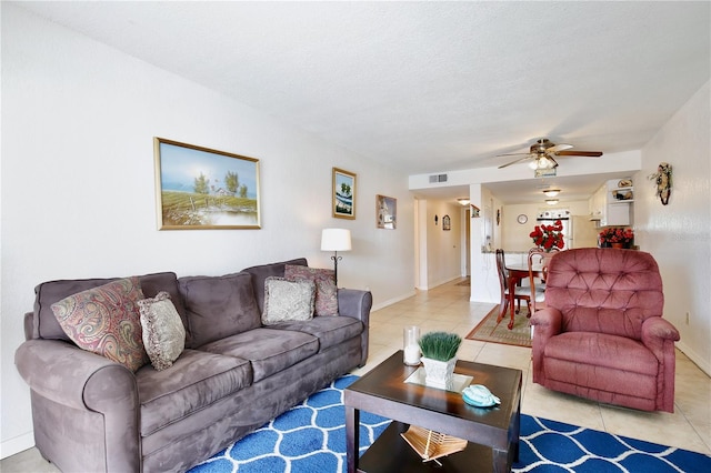 tiled living room featuring ceiling fan and a textured ceiling