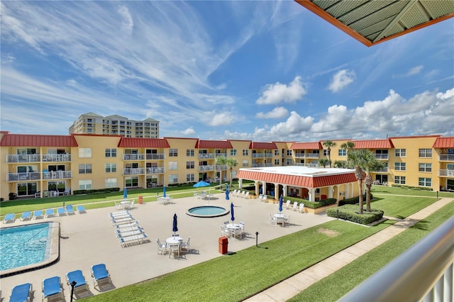 view of community with a yard, a pool, and a patio