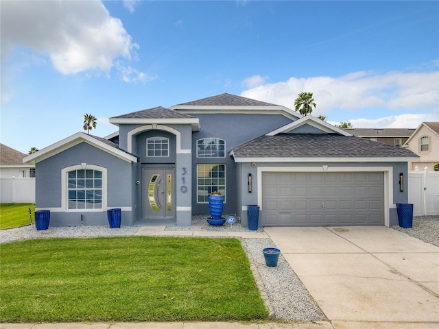 view of front of house with a front lawn, fence, stucco siding, a garage, and driveway