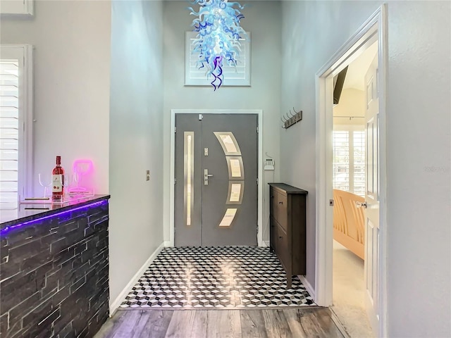 foyer with wood-type flooring and a notable chandelier