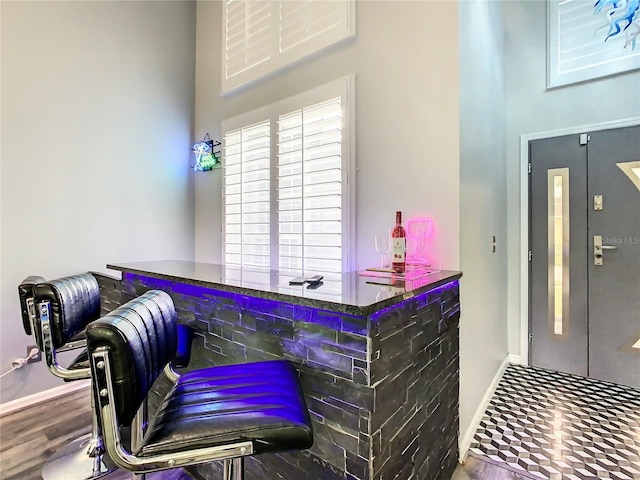 bar with wood-type flooring and elevator