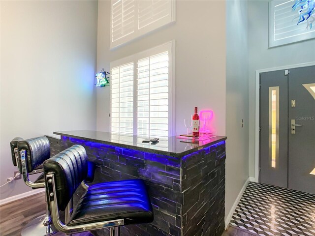 bar with baseboards and a towering ceiling