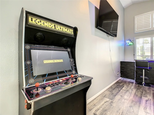 recreation room featuring lofted ceiling, wood finished floors, and baseboards