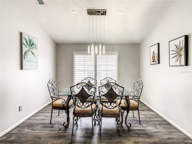 dining space with baseboards, dark wood-type flooring, and a textured ceiling