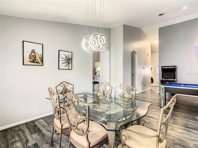 dining room featuring visible vents, lofted ceiling, baseboards, and wood finished floors