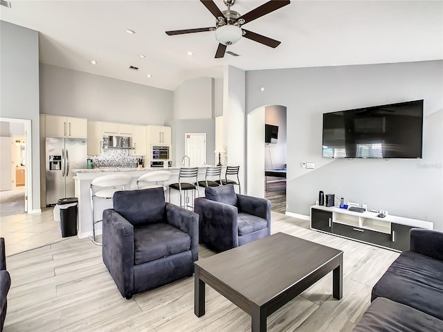 living room featuring high vaulted ceiling and ceiling fan